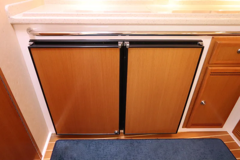 Slide: The Image of 2007 Cabo 40 Hardtop Express interior with wooden cabinetry and blue rug. - 41