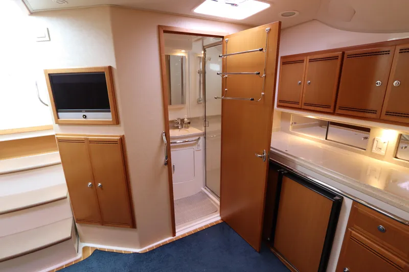 Slide: The Image of 2007 Cabo 40 Hardtop Express interior with kitchenette, cabinets, and bathroom. - 49