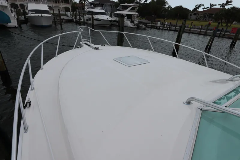 Slide: The Image of 2007 Cabo 40 Hardtop Express boat docked at marina, view of bow and railing. - 6