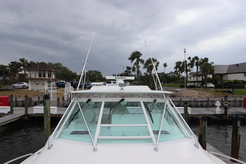 Slide: The Image of 2007 Cabo 40 Hardtop Express docked, showcasing windshield and antennas under cloudy sky. - 7