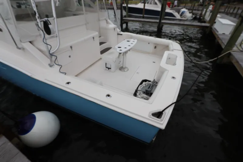 Slide: The Image of 2007 Cabo 40 Hardtop Express boat docked, featuring spacious deck and fishing equipment. - 9