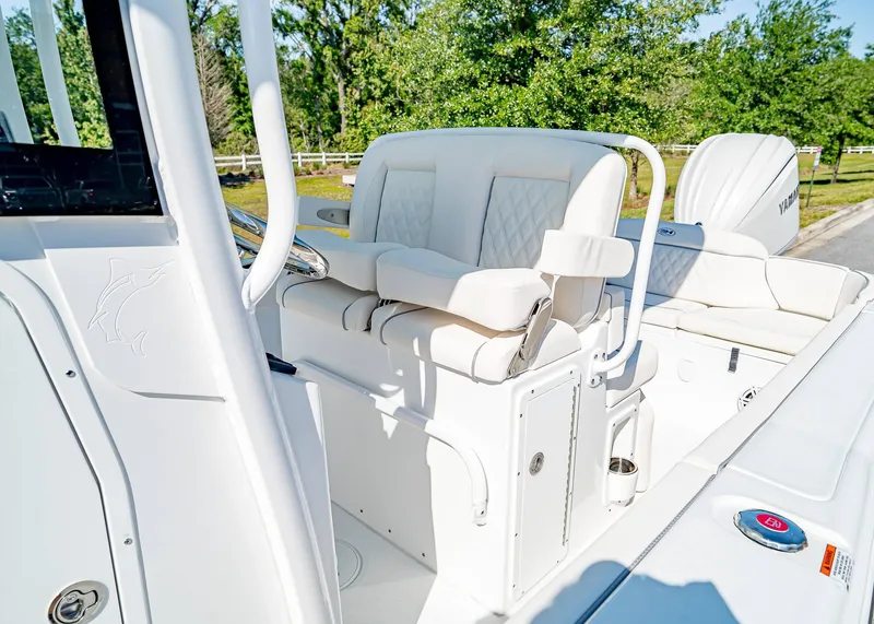 Slide: The Image of 2025 Sea Hunt Ultra 245 SE boat interior with white seating and steering console. - 22