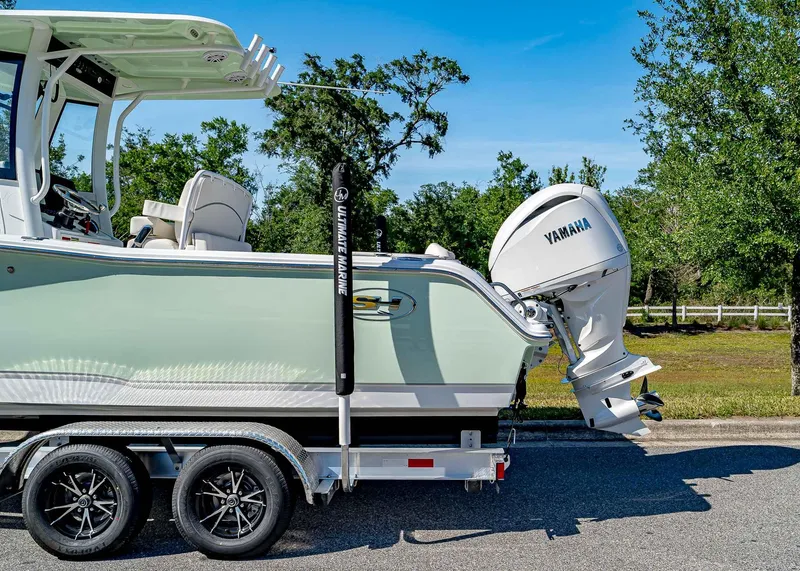 Slide: The Image of 2025 Sea Hunt Ultra 245 SE boat on trailer with Yamaha engine, parked outdoors. - 3