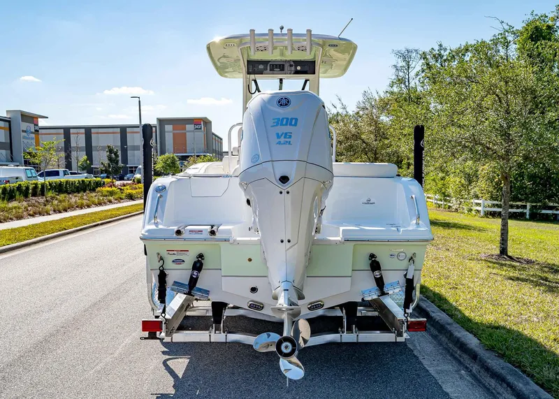 Slide: The Image of 2025 Sea Hunt Ultra 245 SE boat with powerful outboard motor on a sunny street. - 6