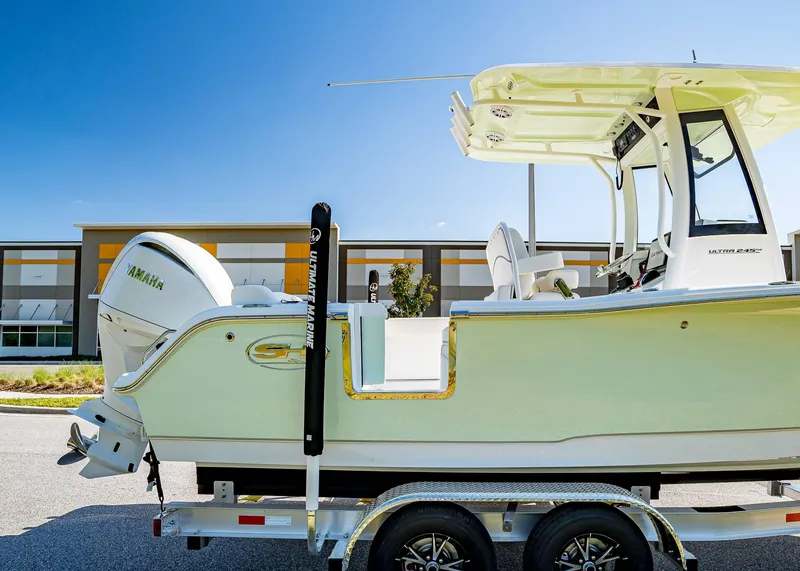 Slide: The Image of 2025 Sea Hunt Ultra 245 SE boat on trailer, featuring Yamaha engine, parked outdoors. - 7