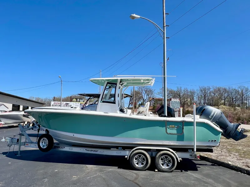 Slide: The Image of 2023 Sea Hunt Ultra 265 SE boat on trailer, parked outdoors under clear blue sky. - 0