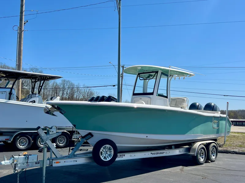 Slide: The Image of 2023 Sea Hunt Ultra 265 SE boat on trailer, parked outdoors under clear blue sky. - 1