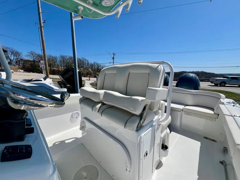 Slide: The Image of 2023 Sea Hunt Ultra 265 SE boat interior with cushioned seating and steering console. - 16
