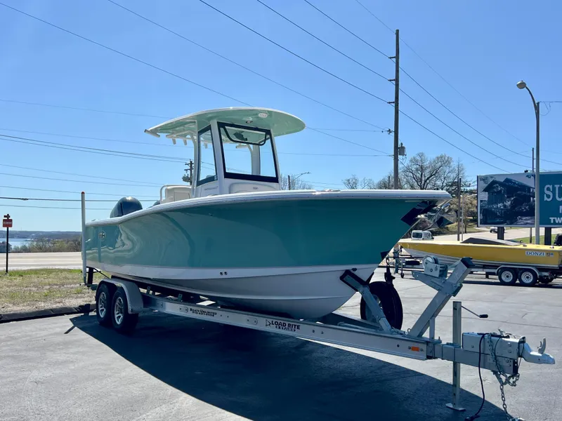Slide: The Image of 2023 Sea Hunt Ultra 265 SE boat on trailer, parked outdoors under clear sky. - 2