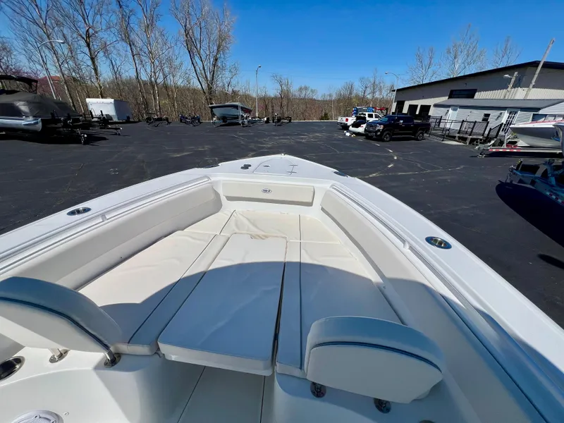 Slide: The Image of 2023 Sea Hunt Ultra 265 SE boat with spacious seating in a parking lot. - 23