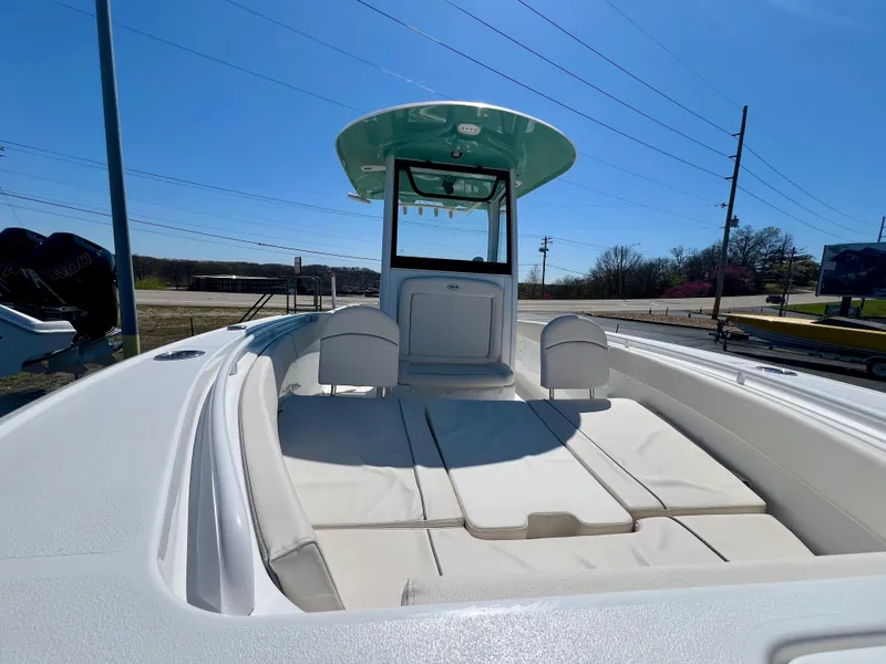 Slide: The Image of 2023 Sea Hunt Ultra 265 SE boat with spacious deck and seating under clear blue sky. - 24