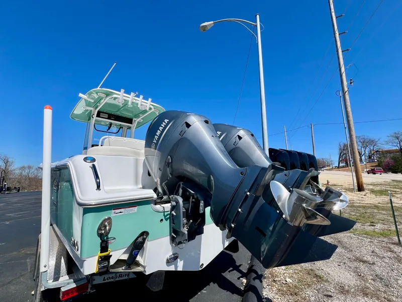 Slide: The Image of 2023 Sea Hunt Ultra 265 SE boat with dual Yamaha outboard motors, parked on a sunny day. - 27