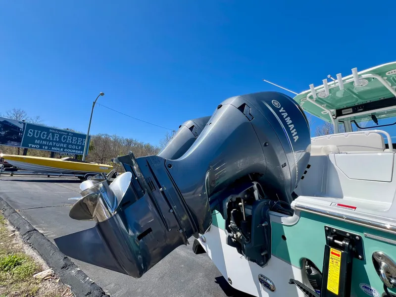 Slide: The Image of 2023 Sea Hunt Ultra 265 SE boat with Yamaha outboard motors, parked on a sunny day. - 28