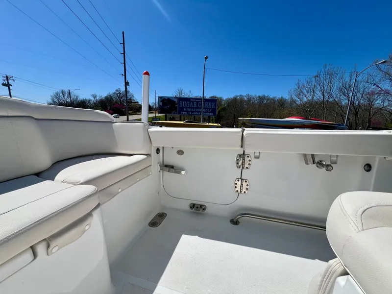 Slide: The Image of 2023 Sea Hunt Ultra 265 SE boat interior with white seating and clear blue sky. - 8