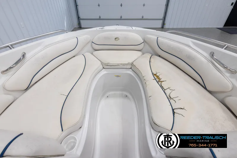 Slide: The Image of 2005 Crownline 216 LS boat interior with white seating and visible wear. - 14