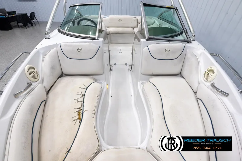 Slide: The Image of 2005 Crownline 216 LS boat interior with worn white seating and open windshield. - 16