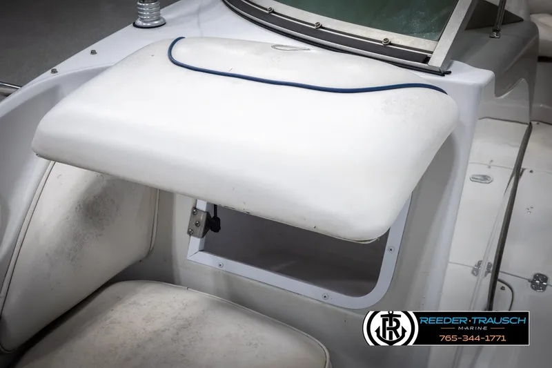 Slide: The Image of 2005 Crownline 216 LS boat interior with white seating and storage compartment. - 22