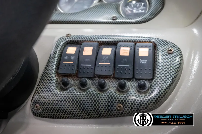 Slide: The Image of Dashboard controls of a 2005 Crownline 216 LS boat with switches and buttons. - 29