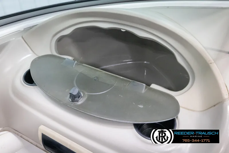 Slide: The Image of 2005 Crownline 216 LS boat storage compartment with cup holders, featuring Reeder-Trausch Marine branding. - 32