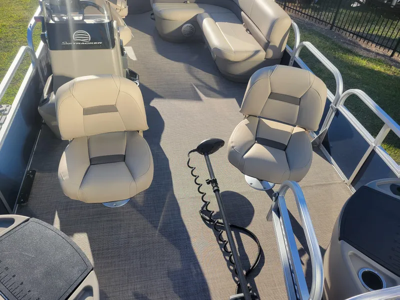 Slide: The Image of 2023 Sun Tracker Bass Buggy 18 DLX interior with beige seating and fishing equipment. - 7