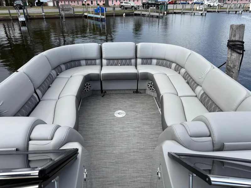Slide: The Image of 2020 Bennington R 25 RFBWA Fastback pontoon boat with spacious seating on a calm lake. - 18