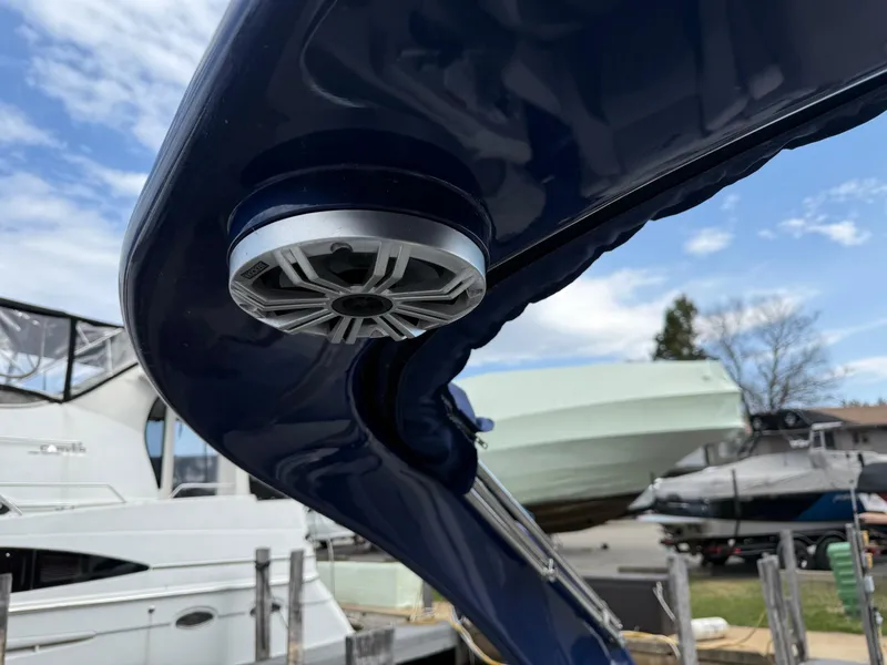 Slide: The Image of 2020 Bennington R 25 RFBWA Fastback boat with speaker, docked under blue sky. - 23