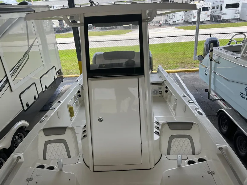 Slide: The Image of 2022 World Cat 235 CC boat interior, featuring center console and seating, in a showroom setting. - 3