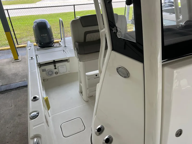 Slide: The Image of 2022 World Cat 235 CC boat interior with seating and motor, parked in a covered area. - 4