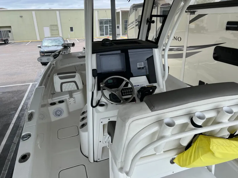 Slide: The Image of 2022 World Cat 235 CC boat interior with helm, steering wheel, and seating. - 5