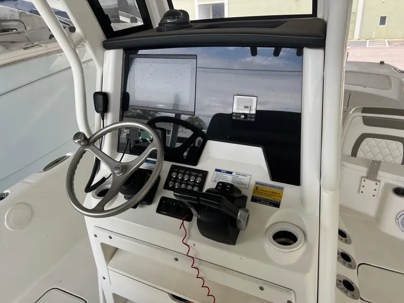 Slide: The Image of 2022 World Cat 235 CC boat console with steering wheel and controls. - 6