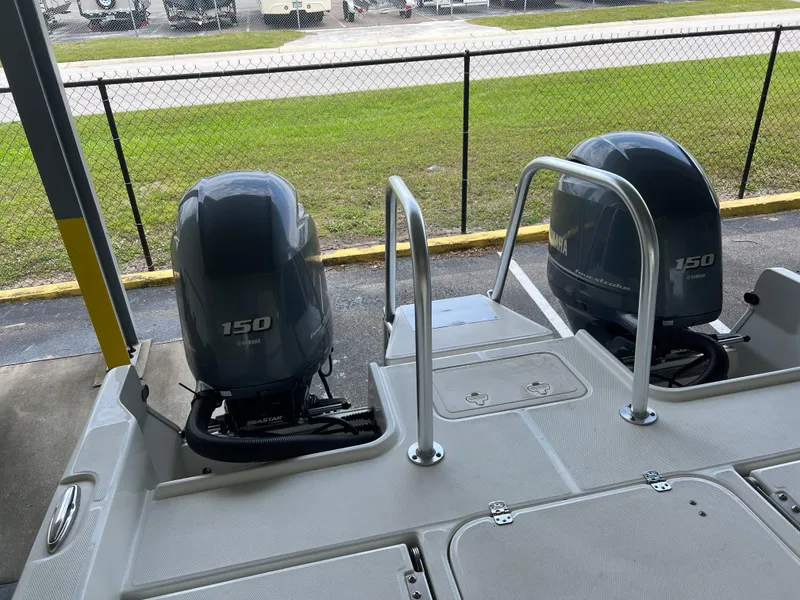 Slide: The Image of 2022 World Cat 235 CC boat with dual 150 horsepower engines, docked near a fence. - 7