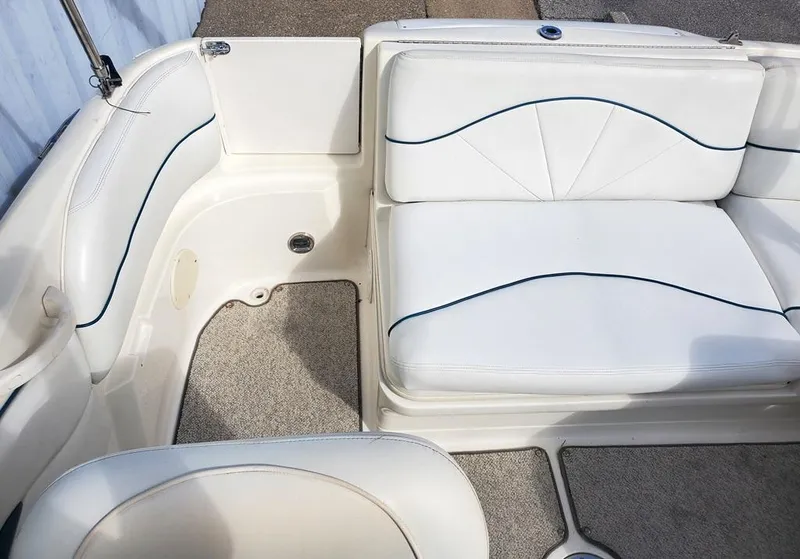 Slide: The Image of 1998 Sea Ray 210 Sundeck interior with white cushioned seating and carpeted flooring. - 11