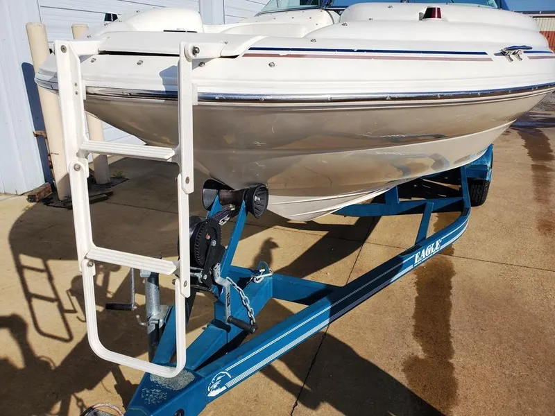 Slide: The Image of 1998 Sea Ray 210 Sundeck boat on blue trailer, parked outdoors. - 18