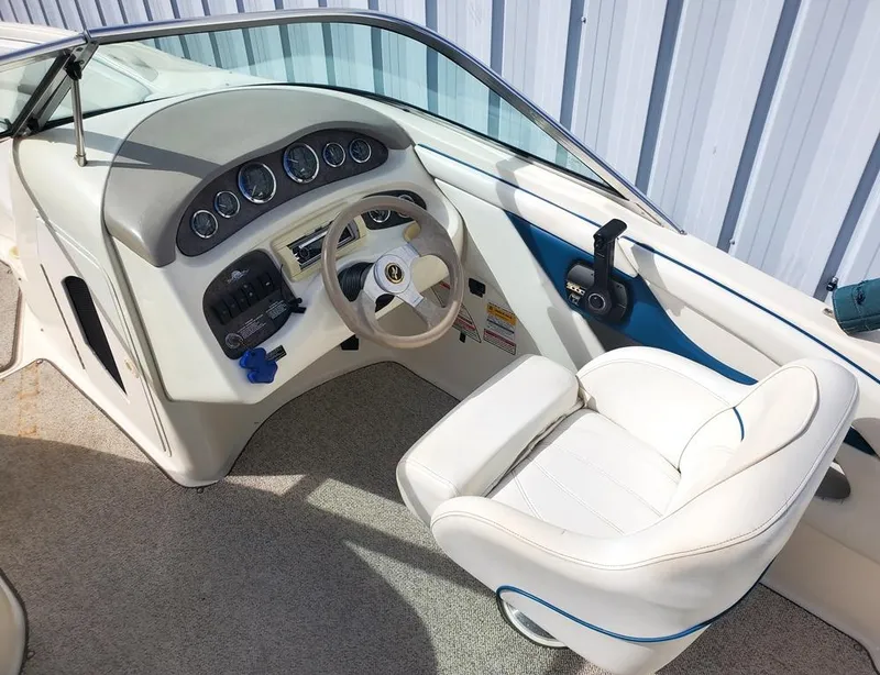 Slide: The Image of Interior of 1998 Sea Ray 210 Sundeck boat with steering wheel and white captain's chair. - 3