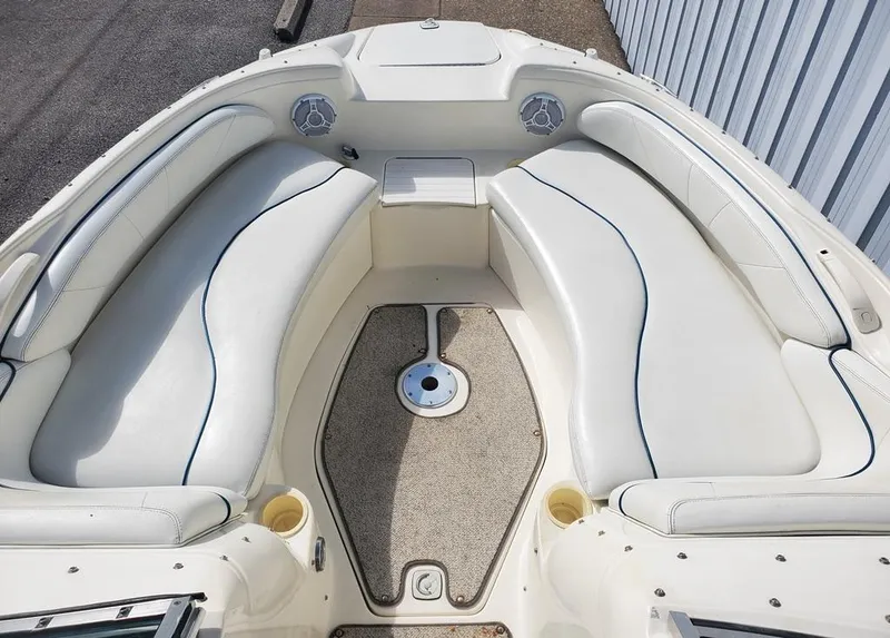 Slide: The Image of 1998 Sea Ray 210 Sundeck boat interior with white cushioned seating and carpeted floor. - 4