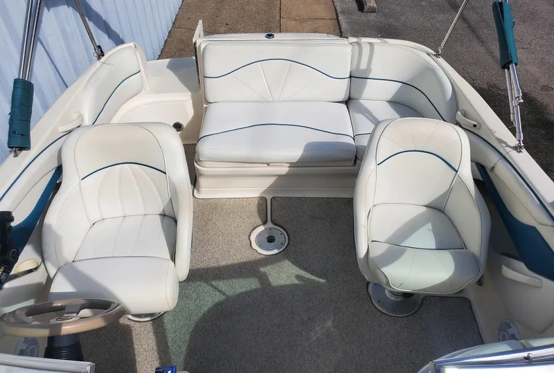 Slide: The Image of 1998 Sea Ray 210 Sundeck interior with white seating and steering wheel. - 7