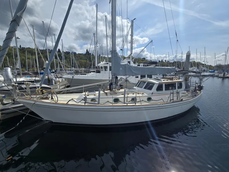 Slide: The Image of 1980 Shannon 38 PH sailboat docked in a marina under a partly cloudy sky. - 1