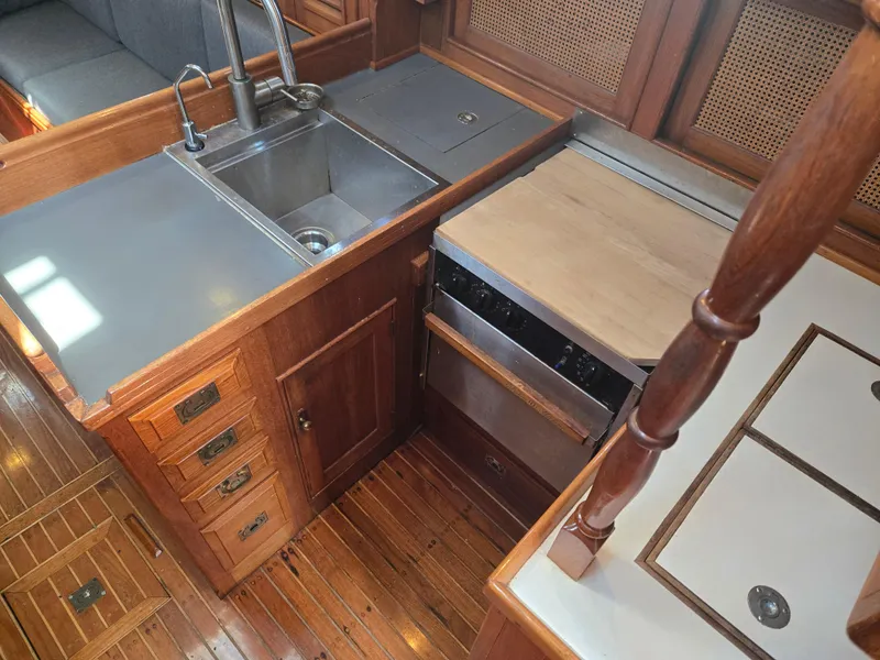 Slide: The Image of 1980 Shannon 38 PH yacht kitchen with wooden cabinetry, stainless steel sink, and stove. - 17