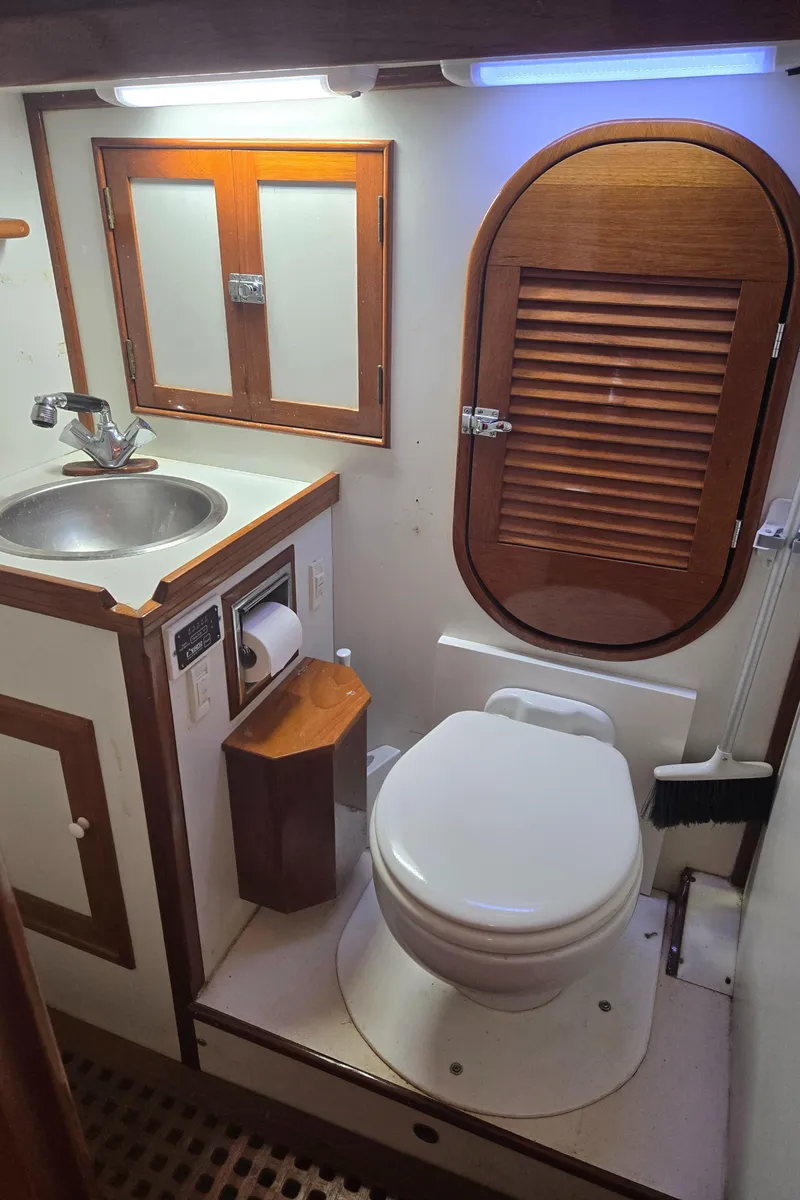Slide: The Image of 1980 Shannon 38 PH yacht bathroom with sink, toilet, and wooden accents. - 25