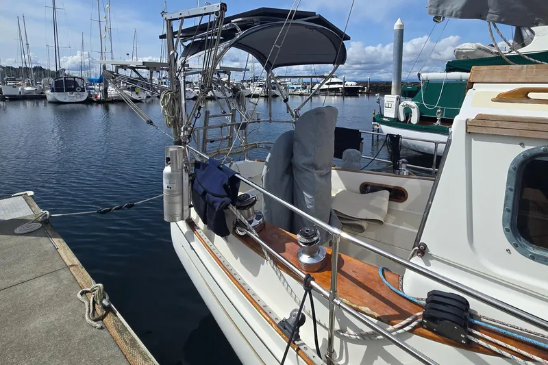 Slide: The Image of 1980 Shannon 38 PH sailboat docked at marina, featuring covered cockpit and nautical equipment. - 3