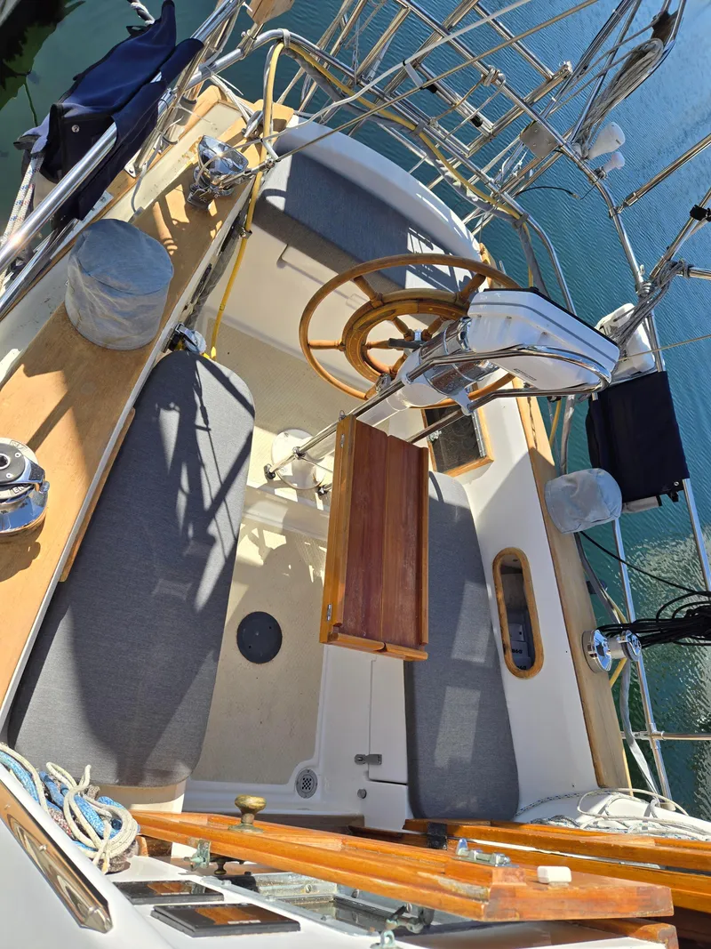 Slide: The Image of Cockpit of 1980 Shannon 38 PH sailboat with wooden wheel and seating. - 6