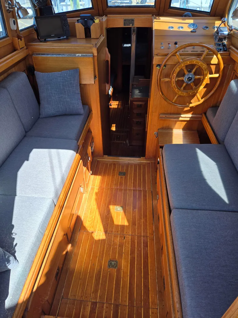 Slide: The Image of Interior of a 1980 Shannon 38 PH boat with wooden flooring and gray seating. - 7