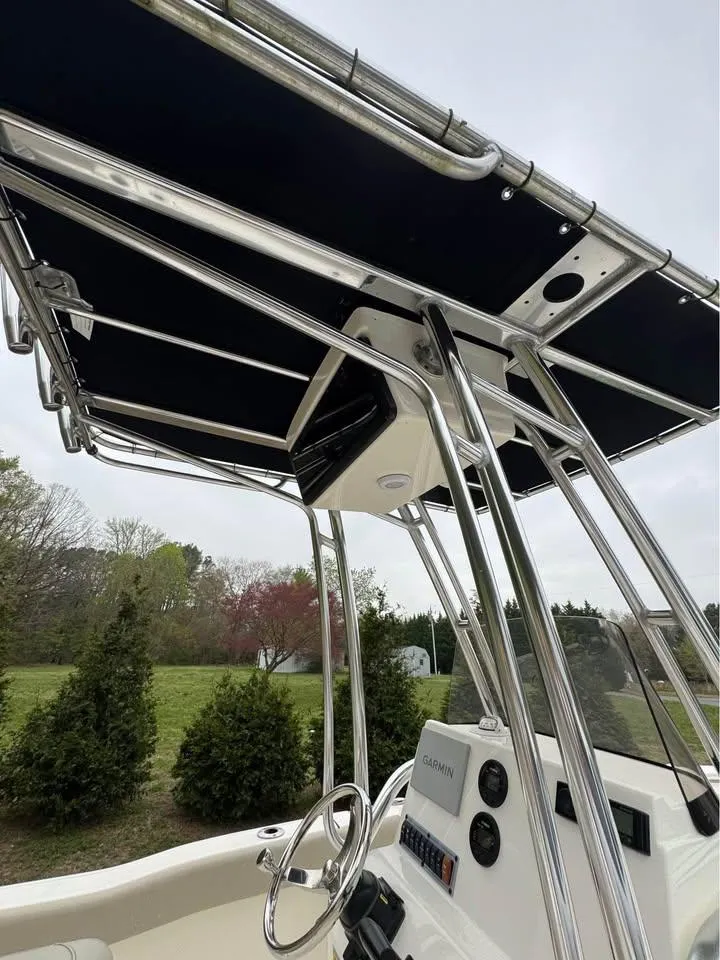 Slide: The Image of 2023 Key West 203 FS boat with sleek console and canopy, set against a natural backdrop. - 9