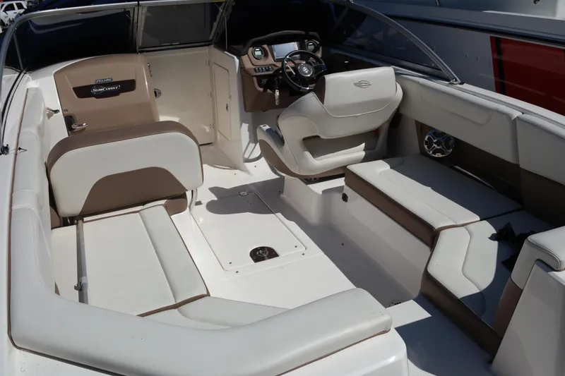 Slide: The Image of 2015 Chaparral 250 Suncoast boat interior with beige and white seating. - 18