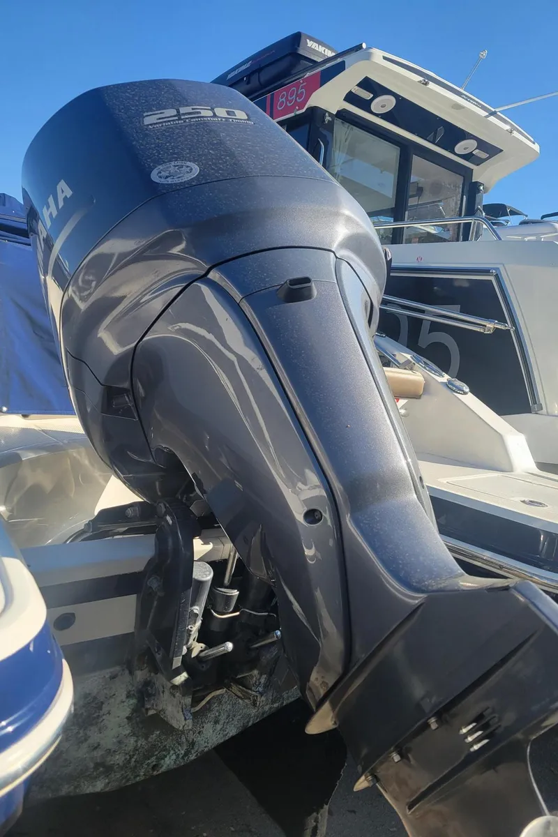 Slide: The Image of 2015 Chaparral 250 Suncoast with Yamaha outboard motor, docked under clear blue sky. - 37