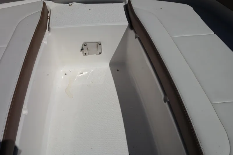 Slide: The Image of 2015 Chaparral 250 Suncoast boat interior, featuring white seating and brown accents. - 7
