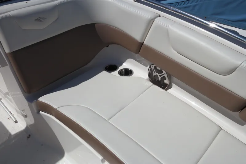 Slide: The Image of 2015 Chaparral 250 Suncoast boat interior with cushioned seating and cup holders. - 8