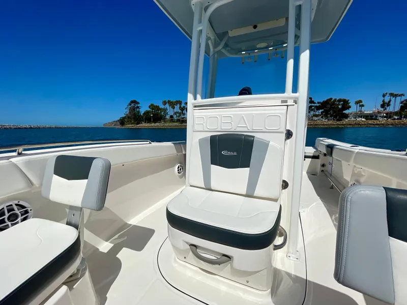 Slide: The Image of 2022 Robalo R230 Center Console boat interior with seating, on a sunny day. - 13