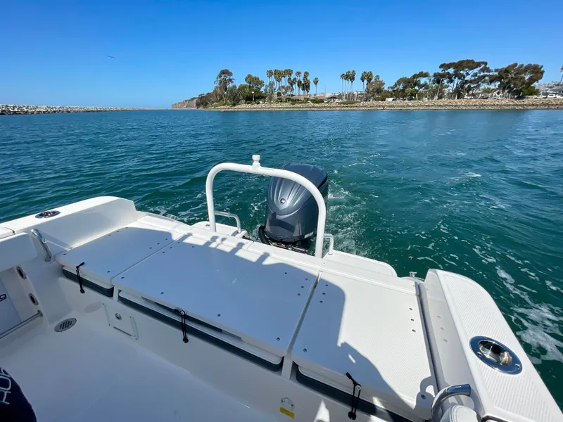 Slide: The Image of 2022 Robalo R230 Center Console boat on water, scenic coastal view. - 14