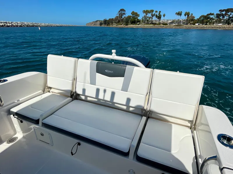 Slide: The Image of 2022 Robalo R230 Center Console boat with white seating, on calm blue water. - 15